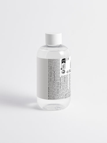 Glycolic acid face toner in a sleek white bottle on a white background from the back side, 290 ml.