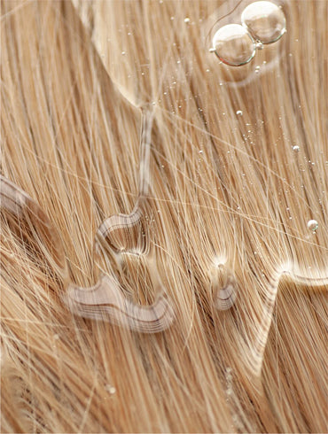 Close-up of blonde hair extensions with a focus on texture and color.