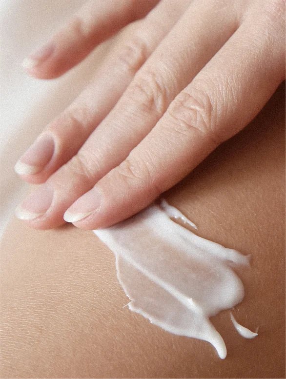Hand applying cream to a person's leg with a close-up view