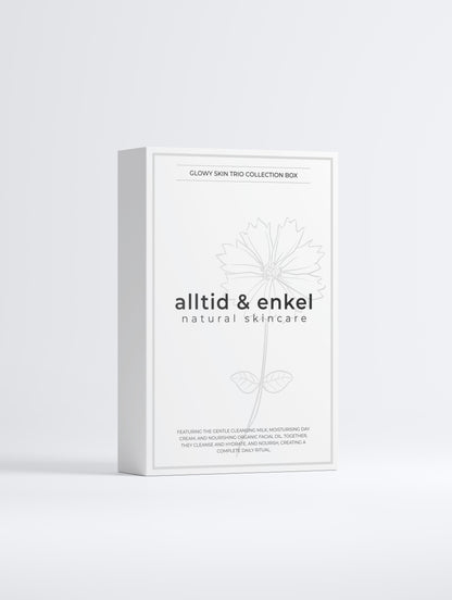 Glowy skin trio collection in a sleek white box from the front on a white background.