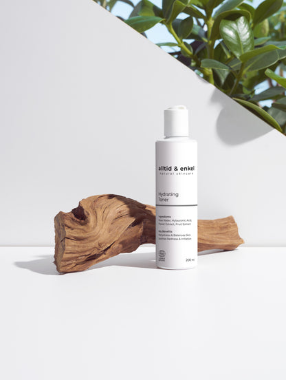 Hydrating toner in a sleek white bottle on a white surface with a wooden log, 200 ml.