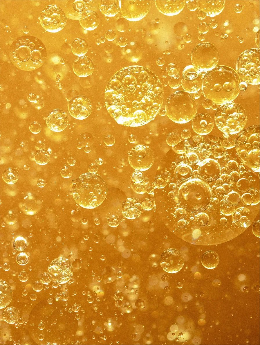 Close-up of biphasic make-up remover on a yellow background.