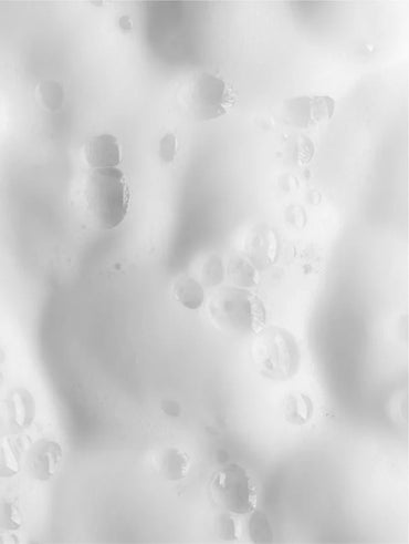 Close-up of cleansing foam texture on a white background.