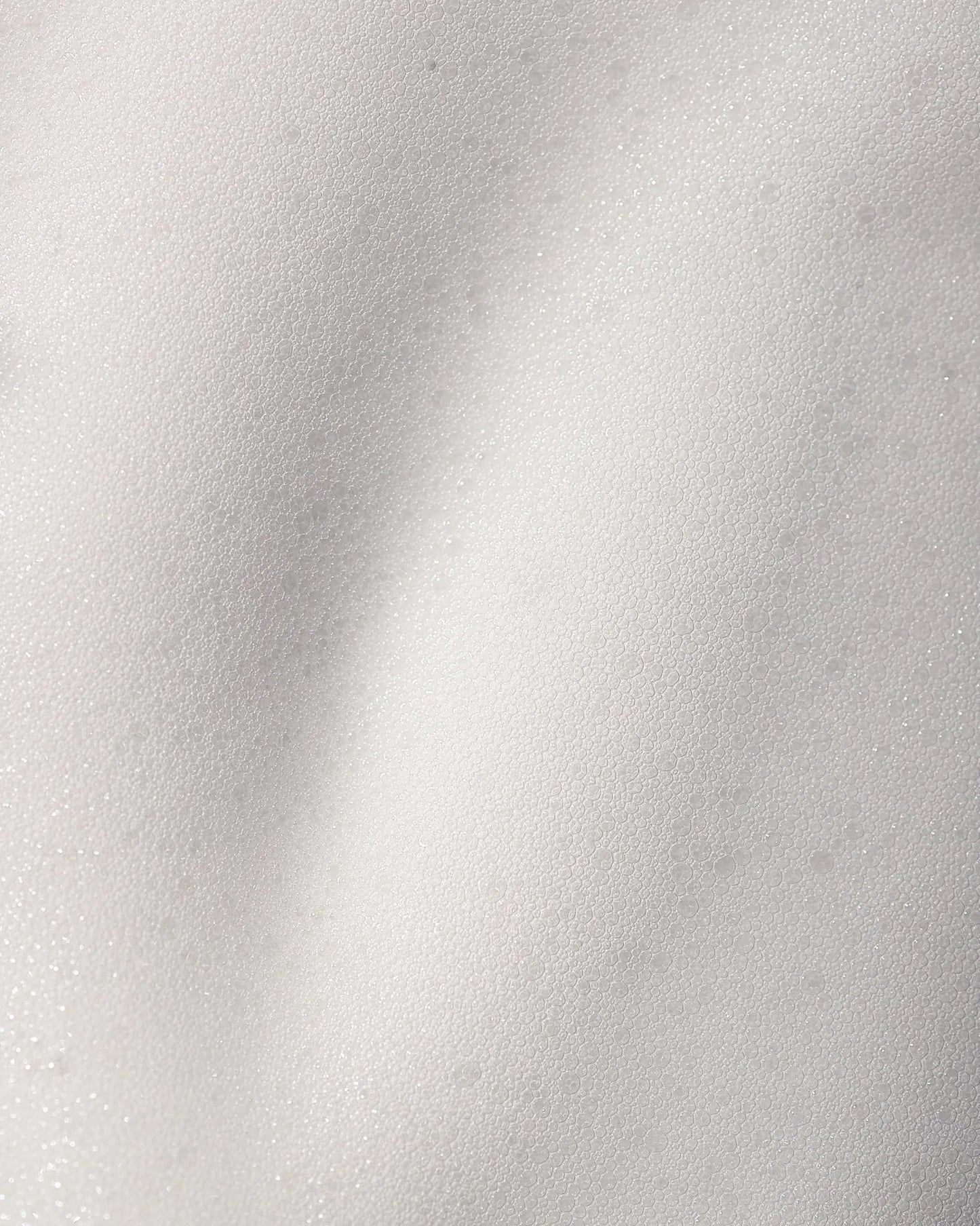 Close-up of cleansing foam texture on a white background.