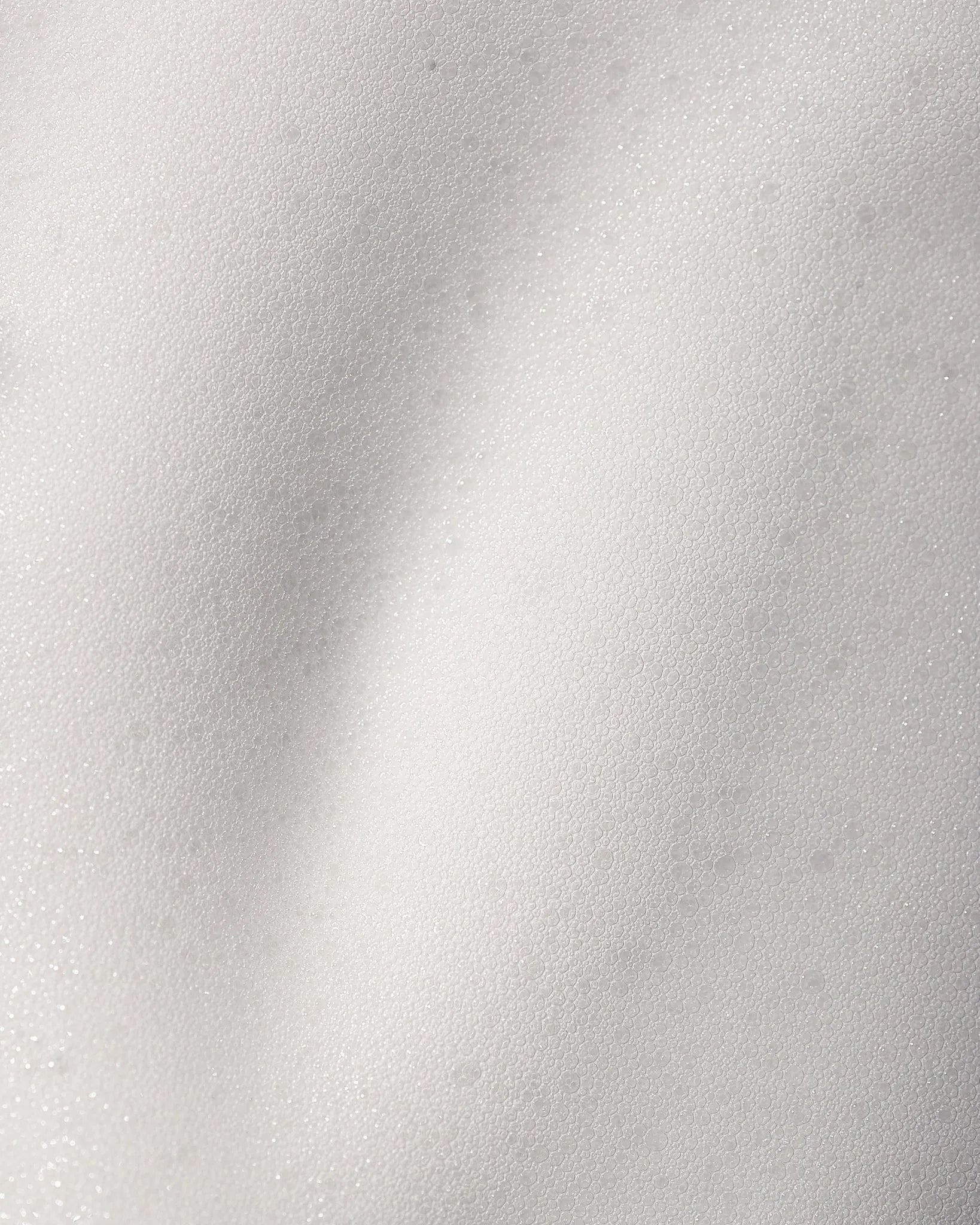Close-up of cleansing foam texture on a white background.