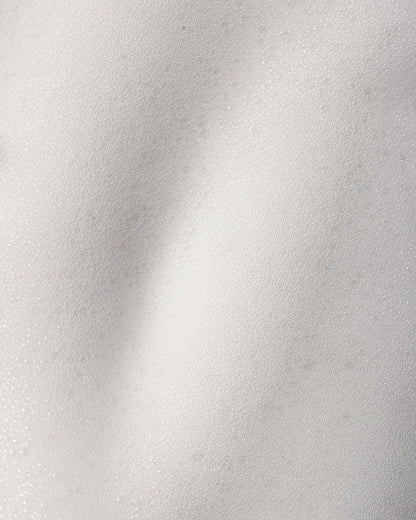 Close-up of cleansing foam texture on a white background.