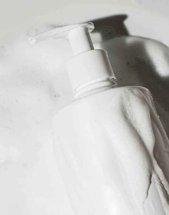 White bottle with pump on a light gray background