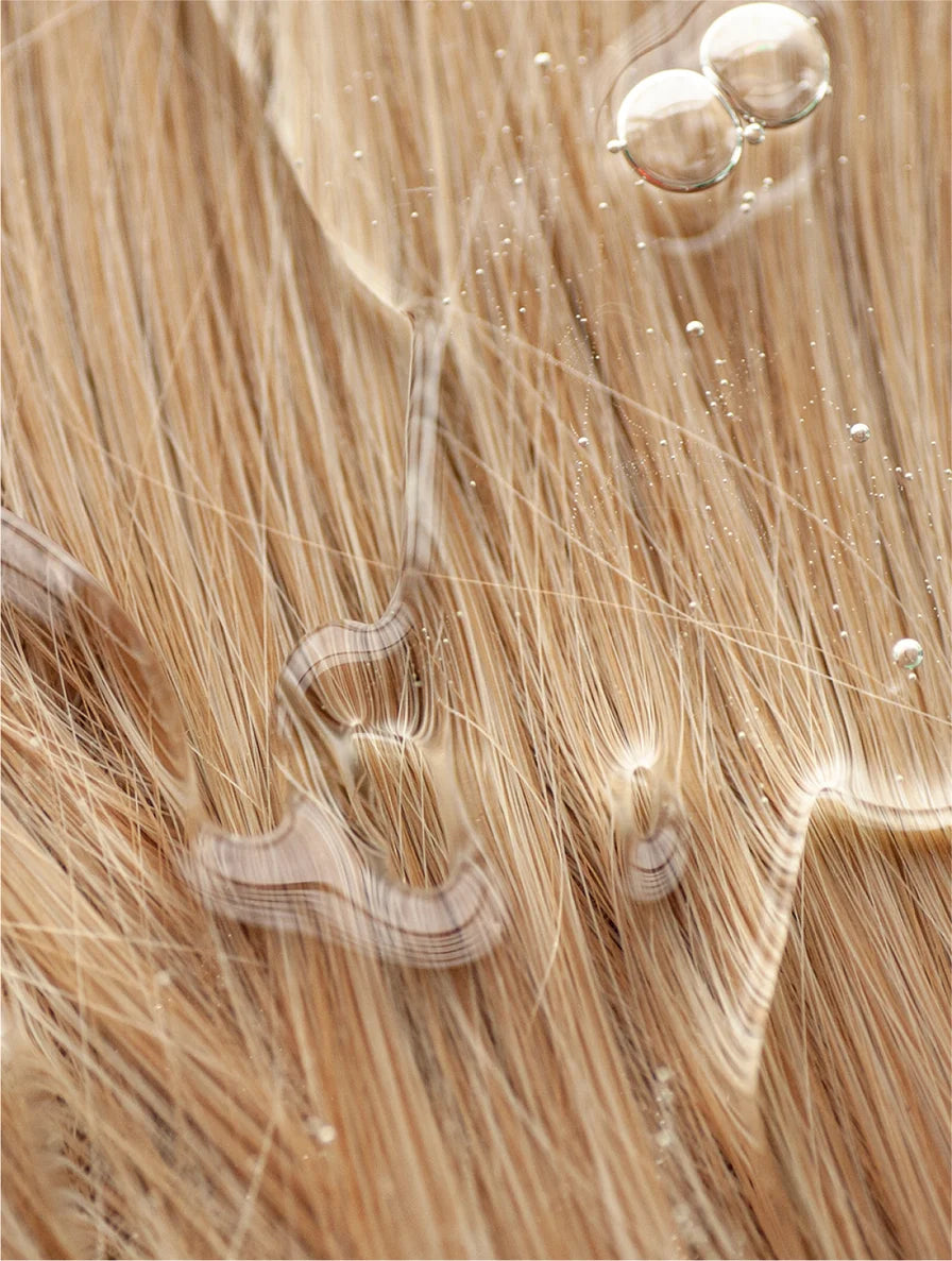 Close-up of blonde hair extensions with a focus on texture and color.