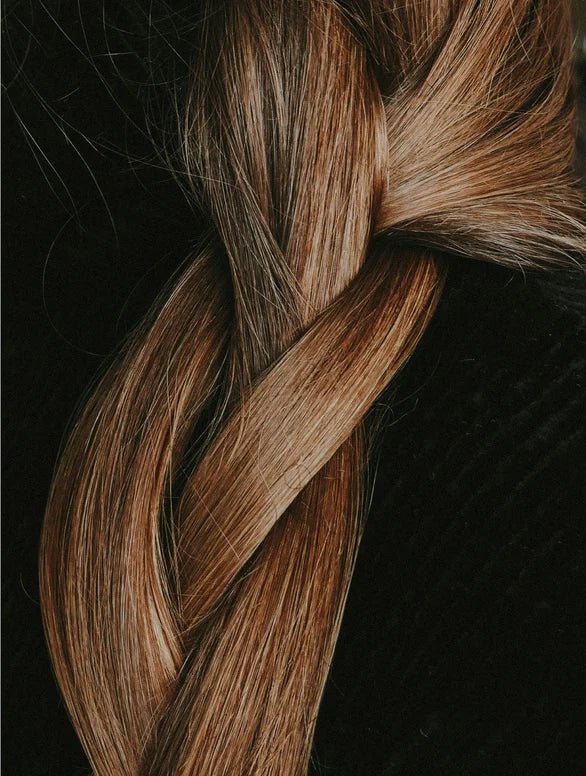 Close-up of a braided hairstyle with brown and blonde hair on a dark background