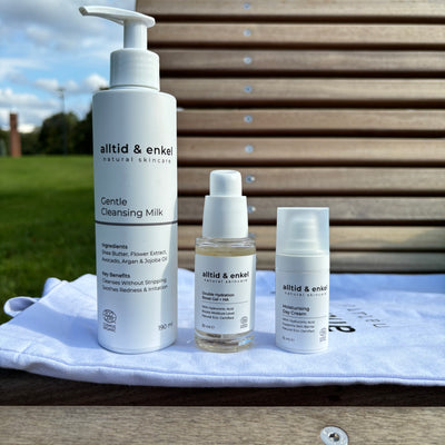 Three skincare products on a white towel with a wooden background