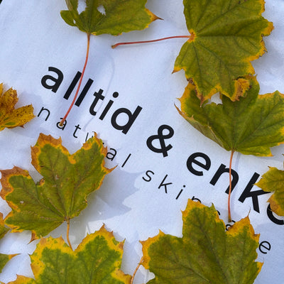 Green leaves on a white shopper bag with  logo.