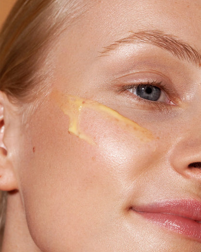 Close-up of a person's face with a cosmetic product applied to the skin.