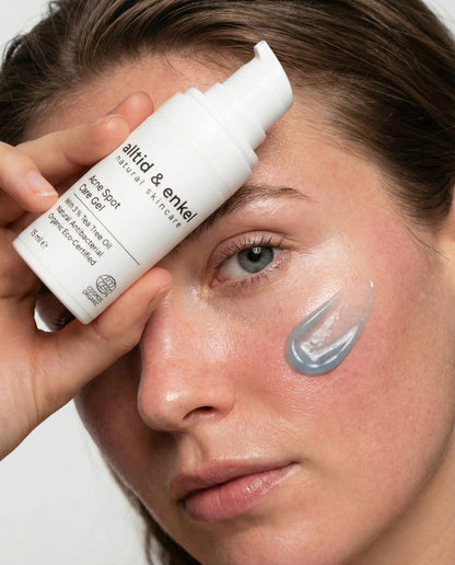 Person applying skincare product to face with 'alltid & enkel' bottle