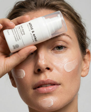 Woman applying a skincare product to her face with a focus on the brand 'alltid & enkel'.