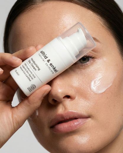 Person applying a skincare product to their face with a bottle labeled 'alltid & enkel'.